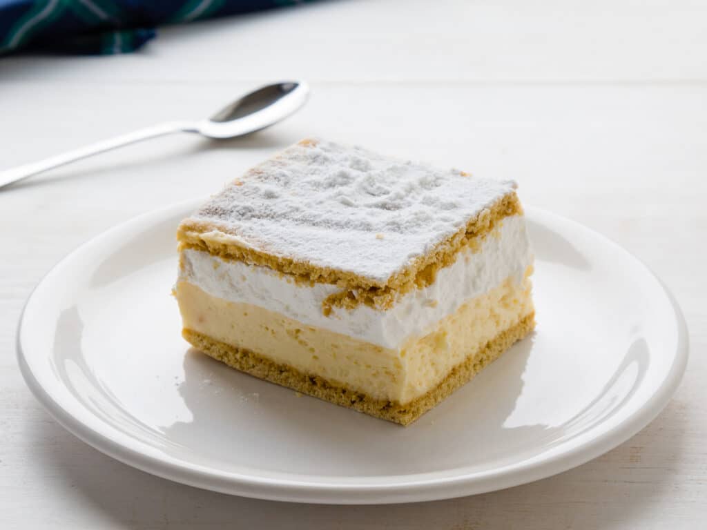 Cream pie with layers of puff pastry on white table