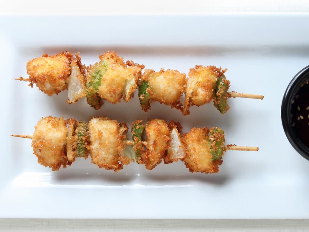 Fried Chicken Kushi sticks with onion and green pepper with dipping sauce.