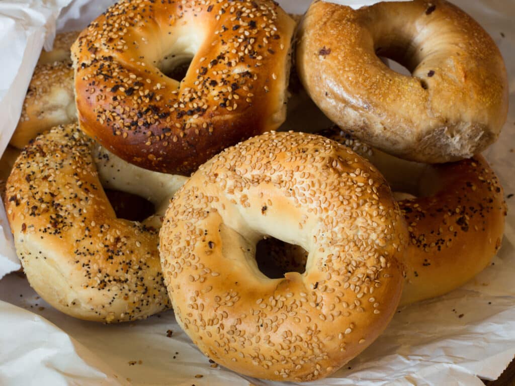 Variety of Authentic New York style bagels with seeds in a paper bag